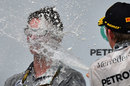 Nico Rosberg sprays Lewis Hamilton's race engineer Andy Shovlin on the podium