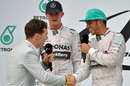 Actor Benedict Cumberbatch greets Lewis Hamilton before interviewing him on the podium