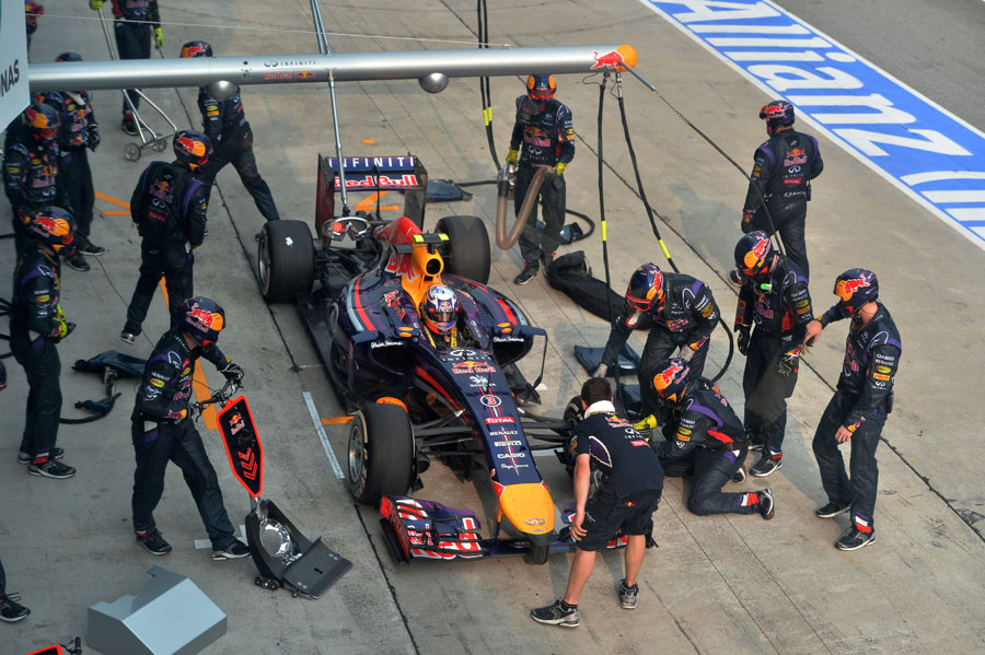 Red Bull's pit crew work on Daniel Ricciardo's car after his botched stop