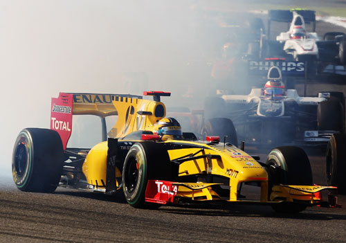 Robert Kubica emerges from the smoke of Mark Webber's Red Bull