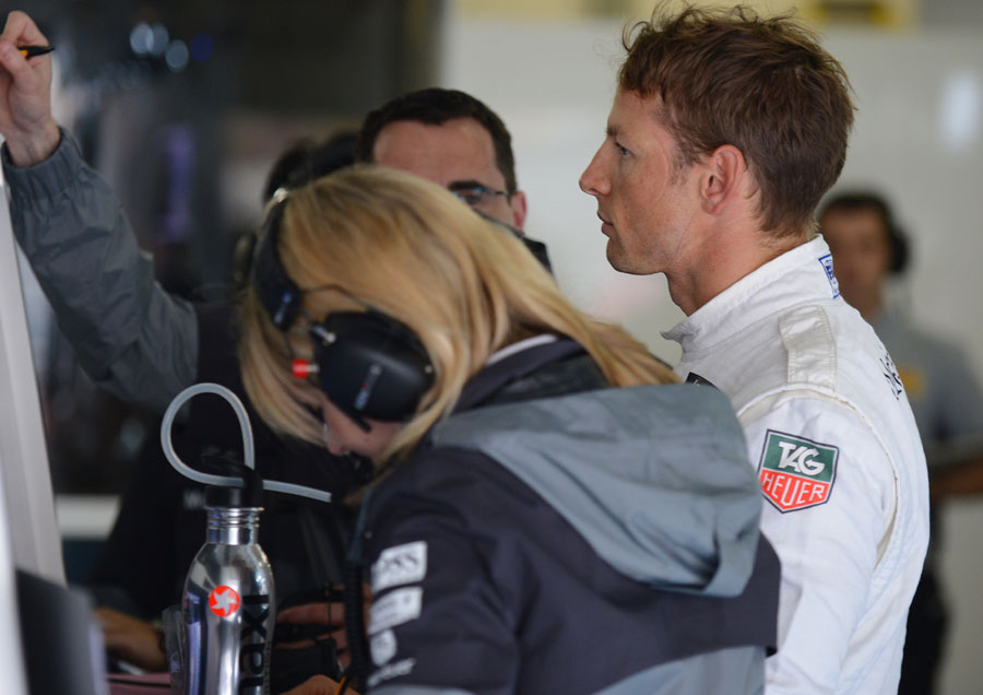 Jenson Button analyses data in the McLaren garage
