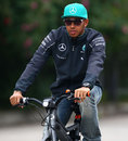Lewis Hamilton cycles through the paddock on race day