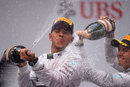 Lewis Hamilton and Nico Rosberg spray champagne on the podium