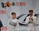 Nico Rosberg hoists aloft his second-place trophy alongside race-winner Lewis Hamilton