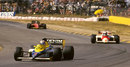 Nigel Mansell rounds a curve with Alain Prost in his rear-view mirrors