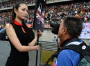 A cameraman snaps away at a grid girl before the start of the race