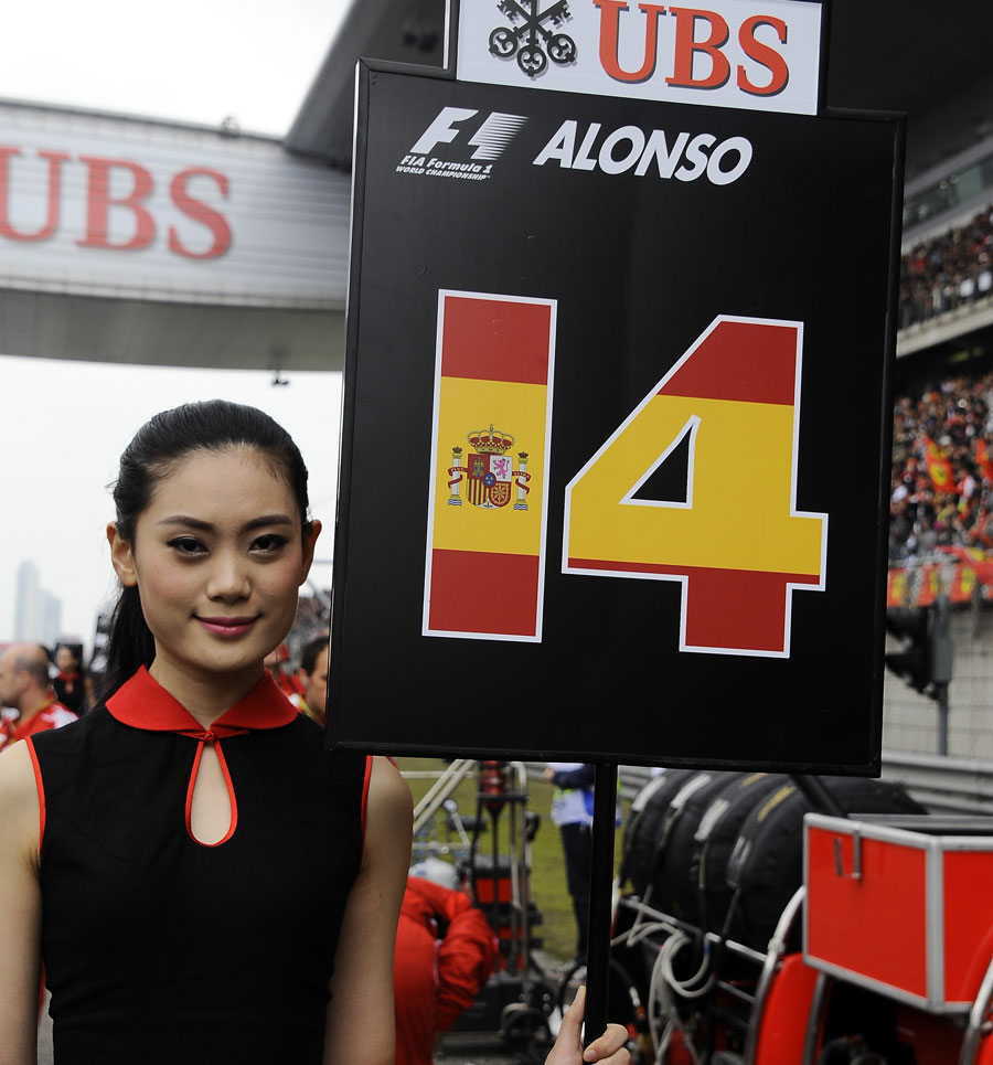 A grid girl stands alongside Fernando Alonso's grid slot