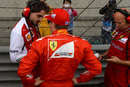 Kimi Raikkonen talks with his engineer ahead of the race
