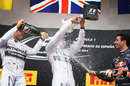 Lewis Hamilton is drenched with champagne from all corners, flanked by Nico Rosberg and Daniel Ricciardo