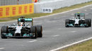 Lewis Hamilton completes a lap with Nico Rosberg in close company