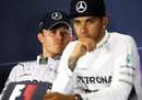 Nico Rosberg looks on as Lewis Hamilton talks in the post-race press conference