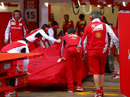 Kimi Raikkonen's Ferrari is wheeled back into the garage after stopping on track