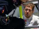 Sebastian Vettel talks to his engineer on the pit wall