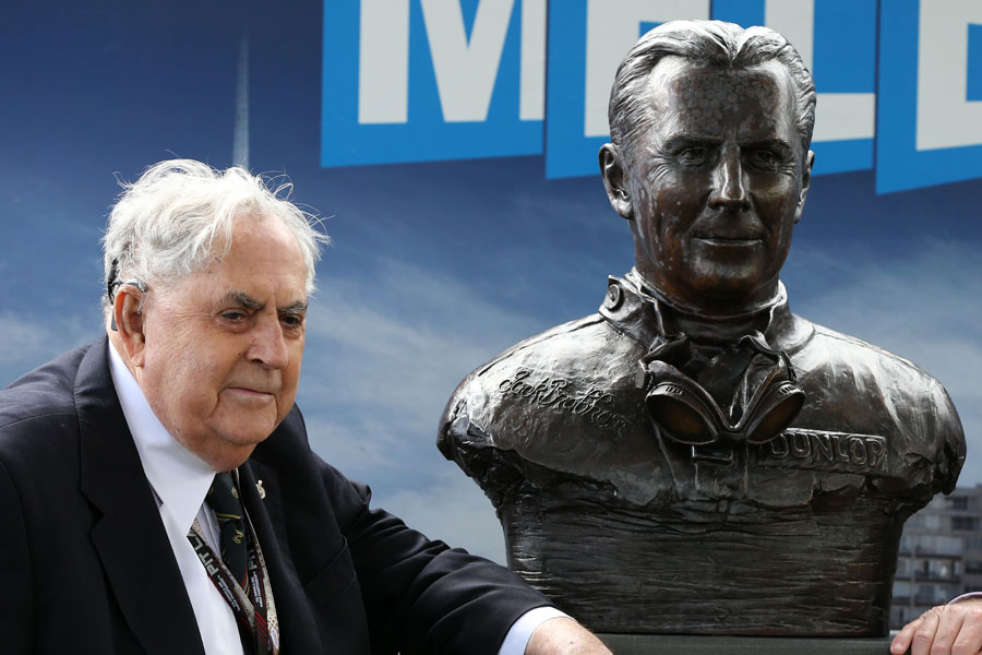 Sir Jack Brabham stands alongside a bust honouring his achievements in F1