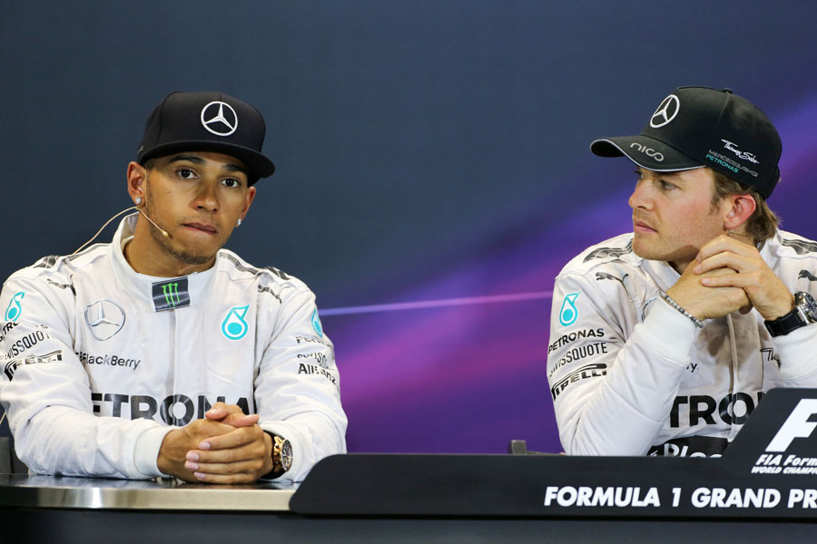 Nico Rosberg looks on as Lewis Hamilton answers a question in the post-race press conference