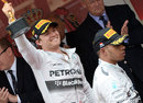 Nico Rosberg celebrates as Lewis Hamilton walks off the podium