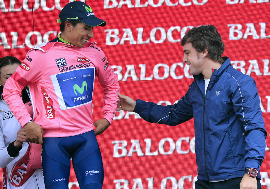 Fernando Alonso hands Colombian Nairo Quintana the leader's maglia rosa after the 18th stage of the Giro d'Italia