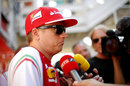 Kimi Raikkonen speaks to the press in the paddock