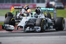 Nico Rosberg hopes over a kerb with Sergio Perez in close attendance