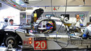 Mark Webber sits in the Porsche 919 Hybrid as mechanics try to get the car back on track