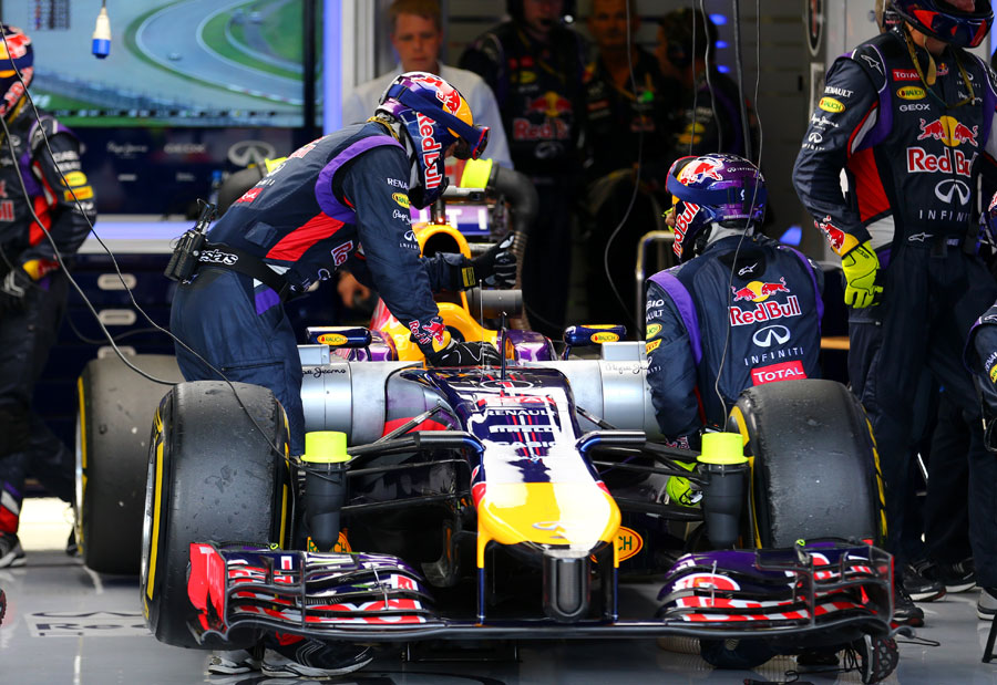 Red Bull pushes Sebastian Vettel's car back into the pits after his retirement