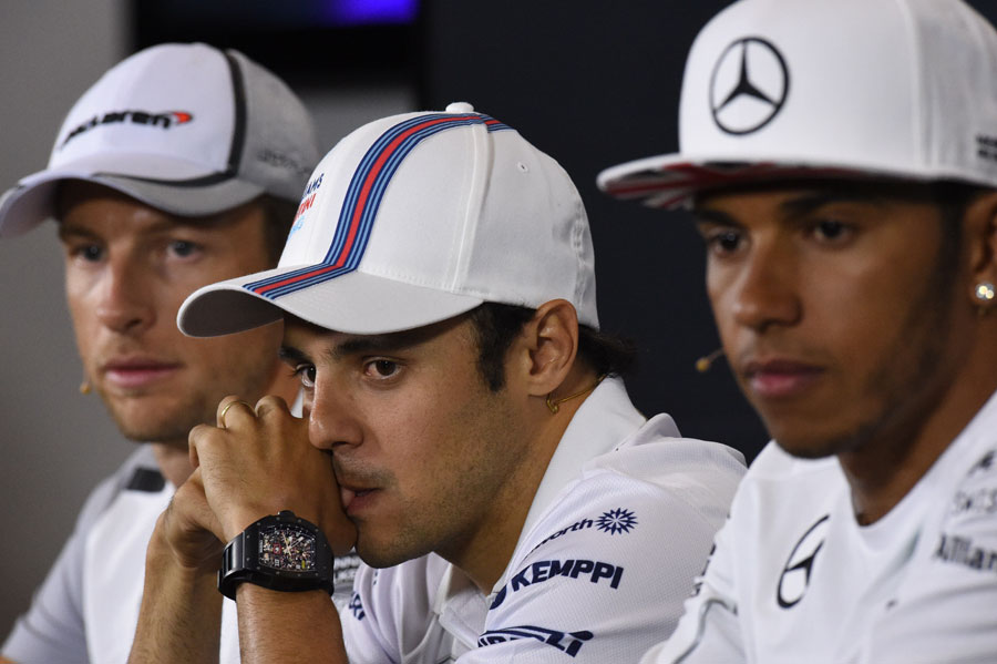 Jenson Button, Felipe Massa and Lewis Hamilton watch on in the press conference