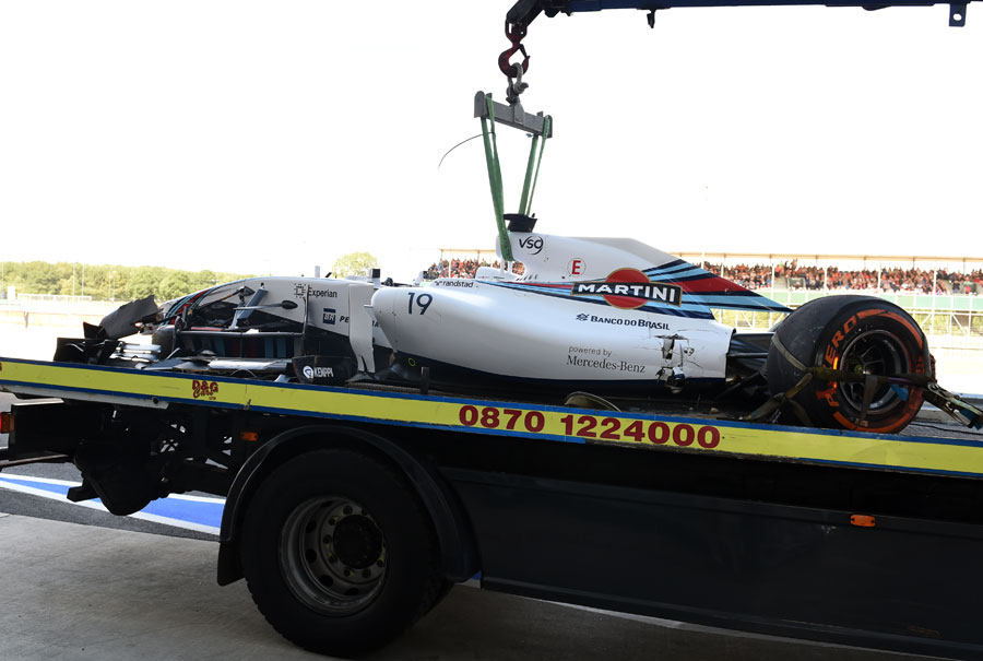 Felipe Massa's wrecked Williams is prepared for the journey back to the pits