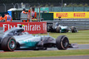 Nico Rosberg passes team-mate Lewis Hamilton's stricken Mercedes
