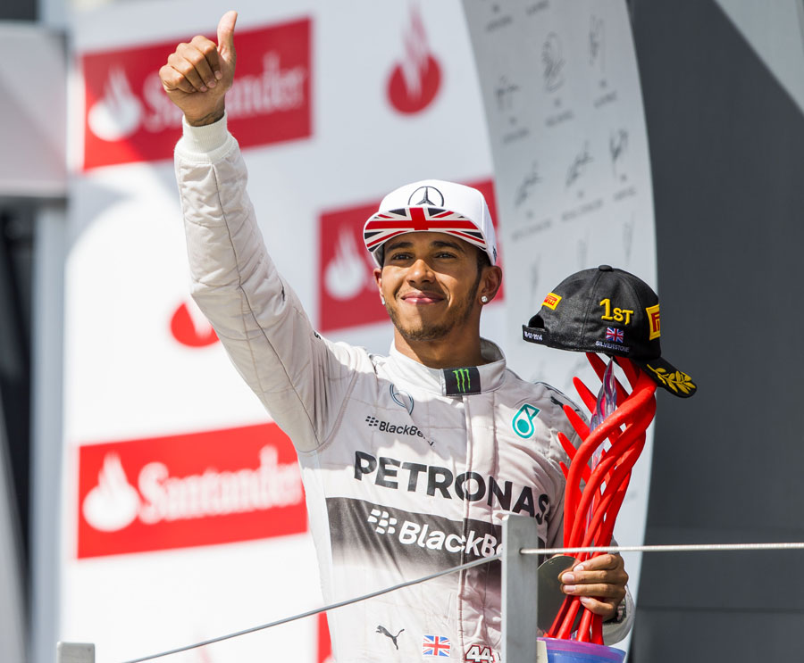 Lewis Hamilton acknowledges the crowd from the podium after his victory