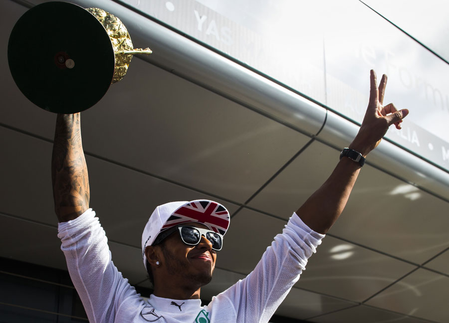 Lewis Hamilton celebrates with his trophy