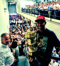 Lewis Hamilton poses with his BRDC trophy and Mercedes employees at the factory in Brackley 