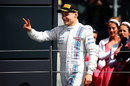 Valtteri Bottas gestures to Williams and the crowd as he arrives on the podium
