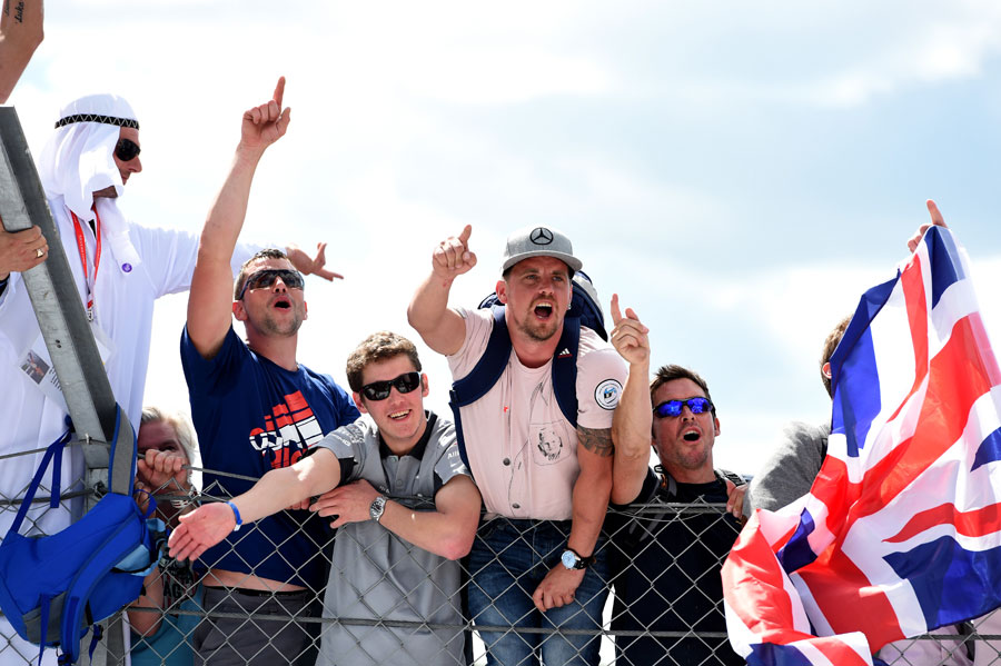 British fans climb the fence to celebrate Lewis Hamilton's victory