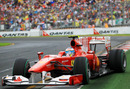 Fernando Alonso sildes his Ferrari right up to the crash barrier