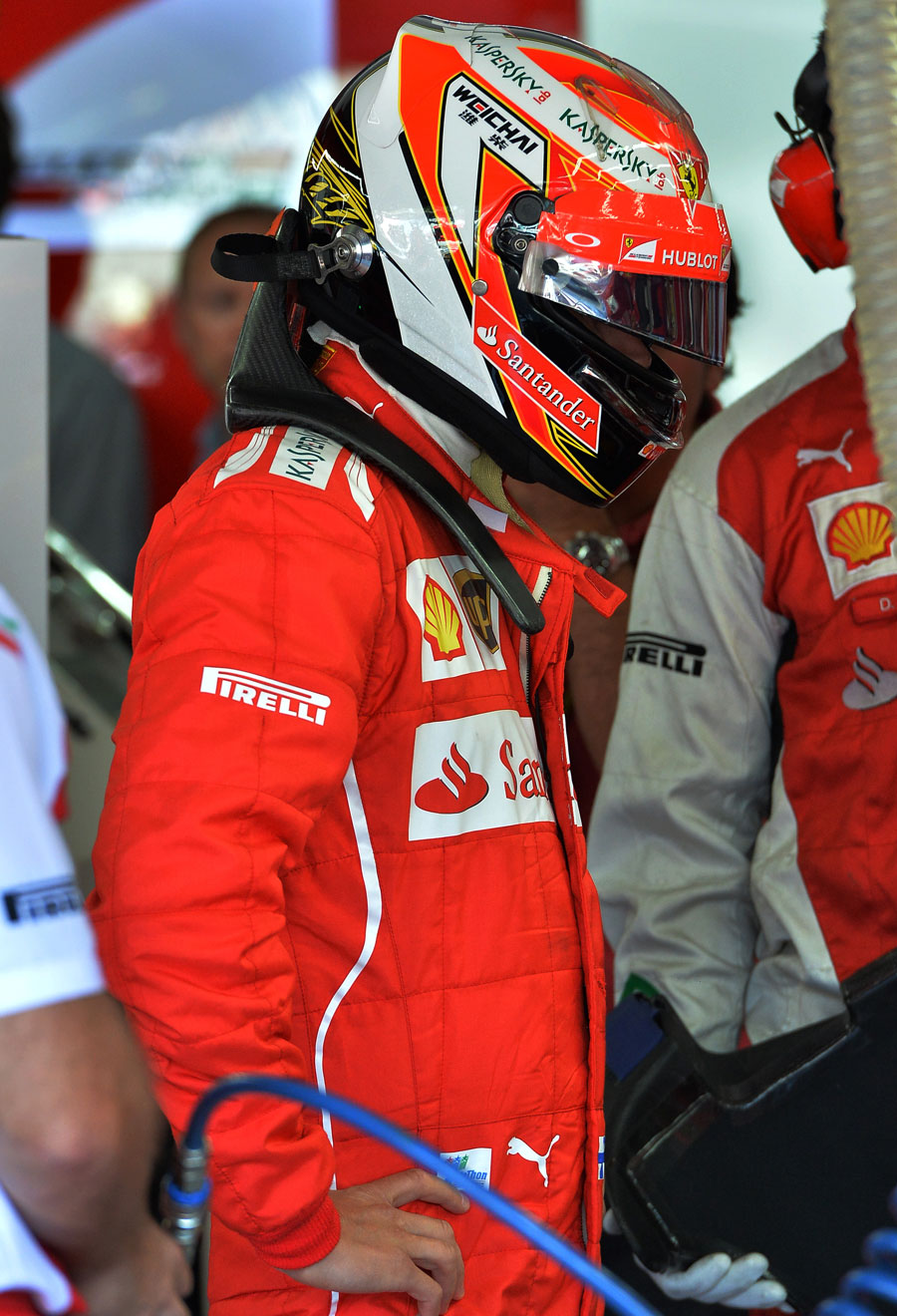 Kimi Raikkonen looks on in the Ferrari garage during qualifying