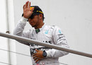 Lewis Hamilton acknowledges the crowd on the podium after finishing third