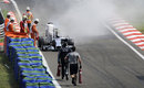 Lewis Hamilton checks his Mercedes after it caught fire during qualifying