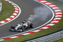 Lewis Hamilton returns to the pits with his car on fire