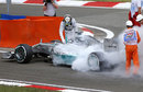 Lewis Hamilton looks down at the cockpit of his smoky Mercedes