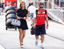 Fernando Alonso and his girlfriend Dasha Kapustina walk through the paddock