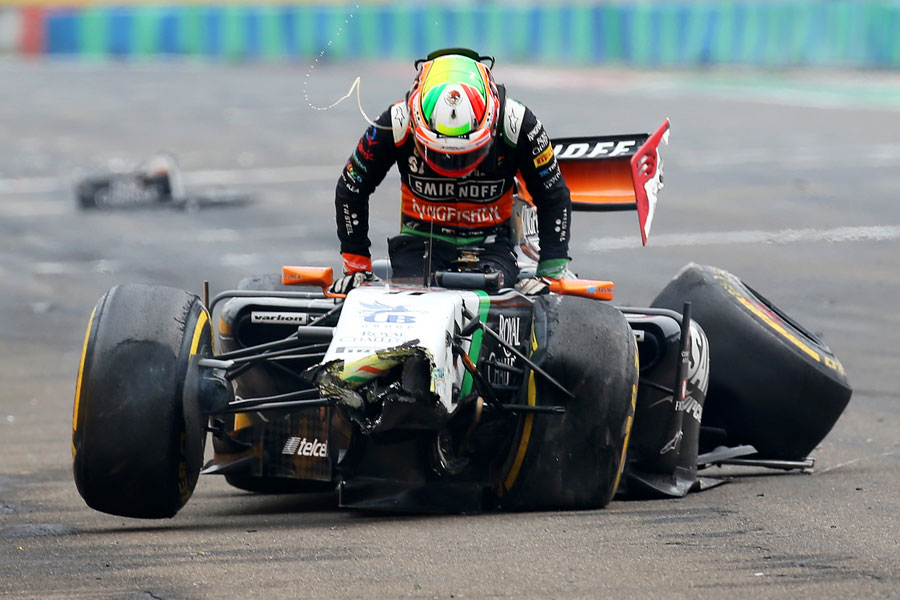 Sergio Perez clambers from his wrecked Force India