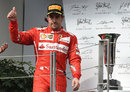 Fernando Alonso waves to the crowd on the podium after taking second