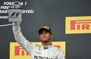 Lewis Hamilton hoists the trophy for third place