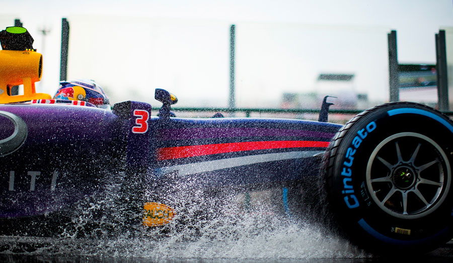 Daniel Ricciardo splashes through a puddle on his way to the grid