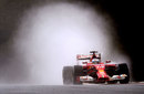 Fernando Alonso cuts a path through the spray