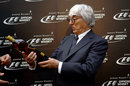 Bernie Ecclestone is presented with a bottle of whisky at a sponsor event