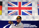 Lewis Hamilton sprays champagne on the podium underneath the Union Jack
