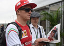 Kimi Raikkonen is handed some fan memorabilia to sign 