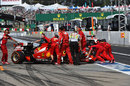 Kimi Raikkonen's Ferrari is wheeled back into the garage