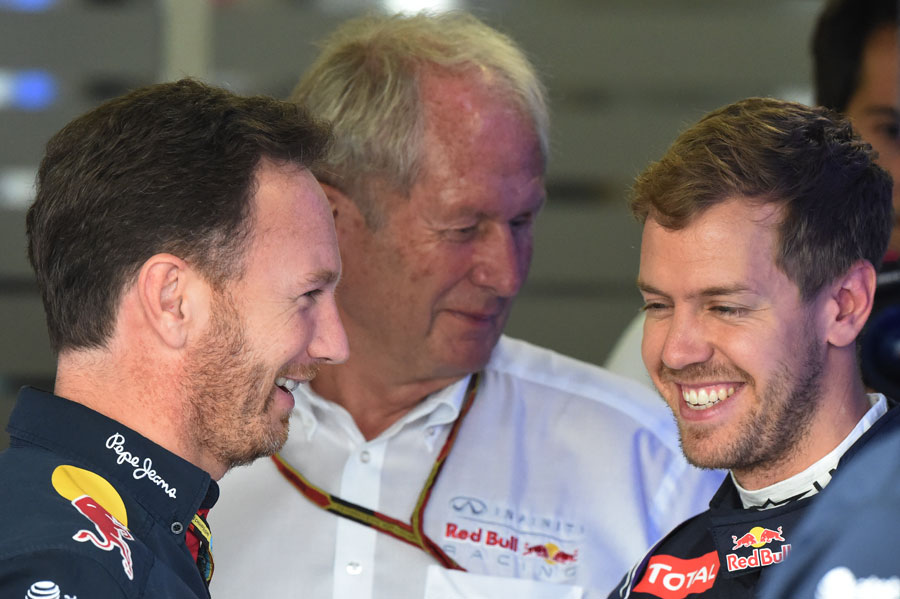 Christian Horner, Helmut Marko and Sebastian Vettel share a laugh in the garage after Red Bull's huge driver announcement on Saturday morning